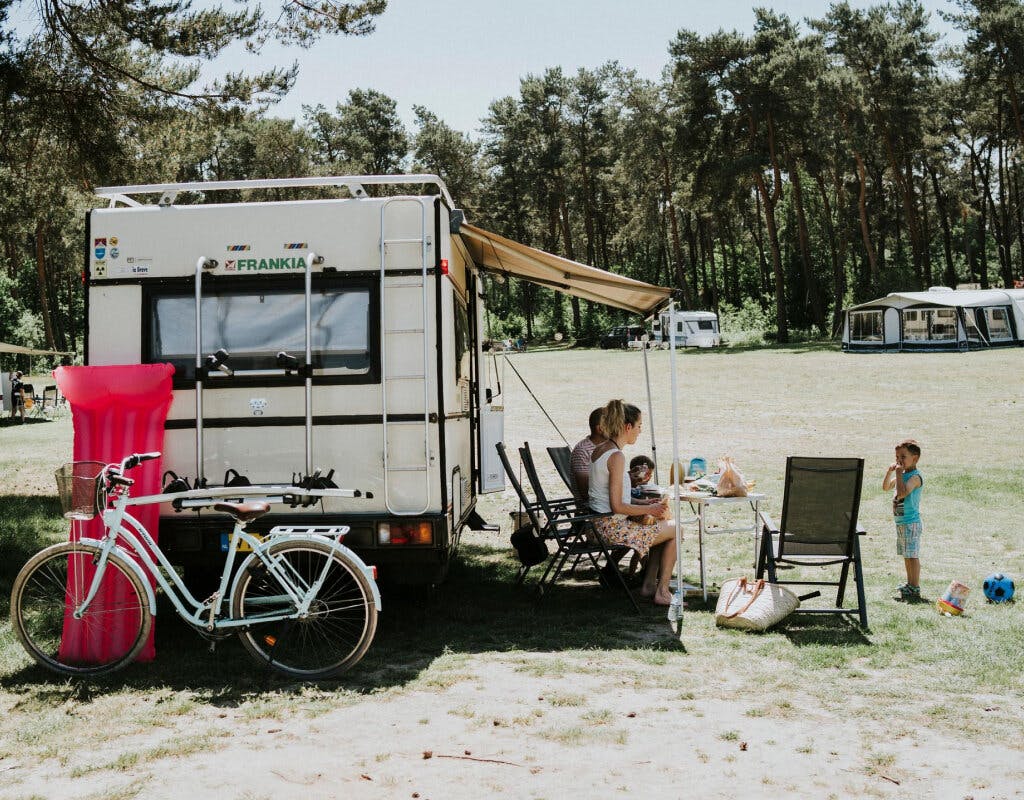 Een gezin kampeert met de caravan op een camping.