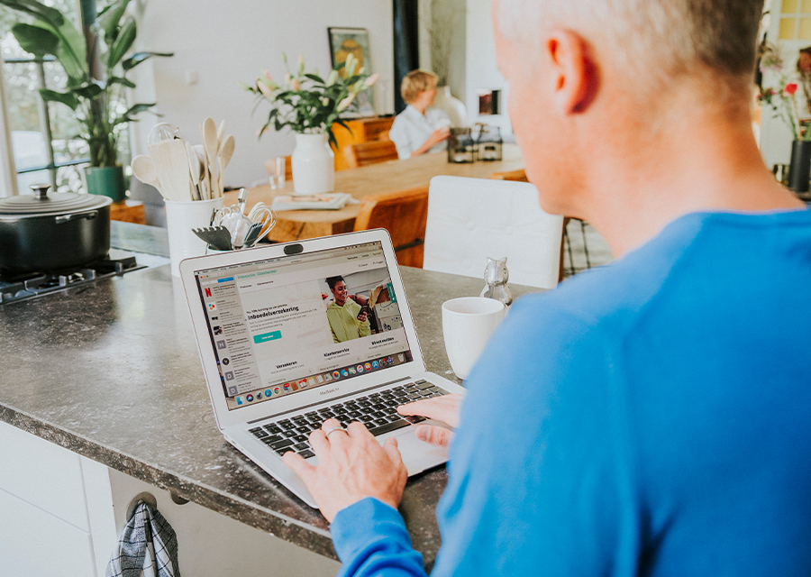 Man die op zijn laptop een Interpolis Overlijdensrisicoverzekering gaat afsluiten.