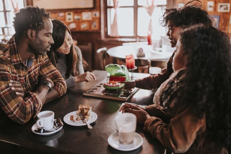 Gezin doet een spelletje en eet een taartje