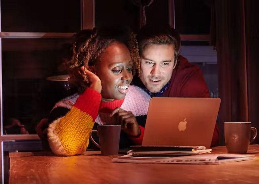 Een man en een vrouw die achter een laptop hun verzekeringszaken regelen.