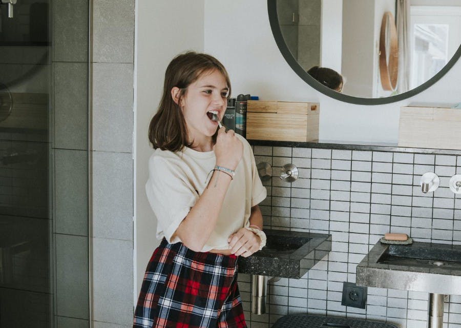 Meisje dat haar tanden poetst. Kies bij een ziektekostenverzekering voor een aanvullende tandverzekering die bij jouw situatie past.