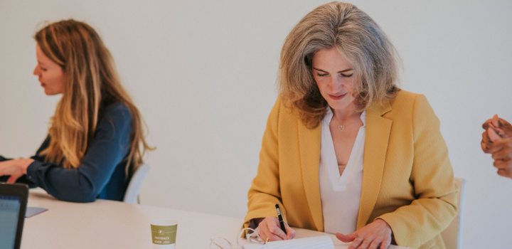 Een belastingadviseur schrijft iets op een papier