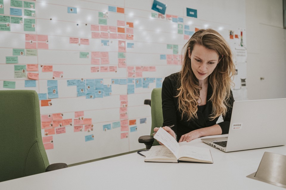 Onderneemster die op haar laptop uitzoekt wat de kosten van een AOV voor haar zijn.