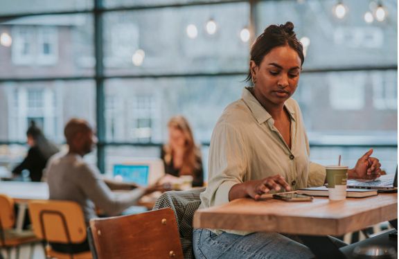 Werknemer kijkt tijdens het werk op haar mobiele telefoon.
