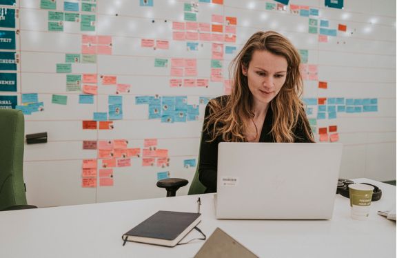 Werkneemster zit achter haar laptop.