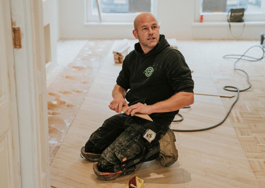 Vloerenlegger zit op zijn knieën