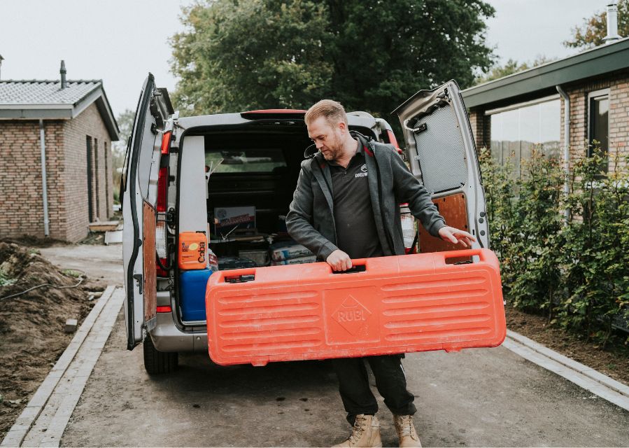 Man haalt gereedschappen uit zijn klussenbus