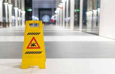 Waarschuwingsbord voor gladheid in een gang op een kantoor