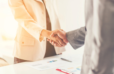 Twee mensen geven elkaar een hand