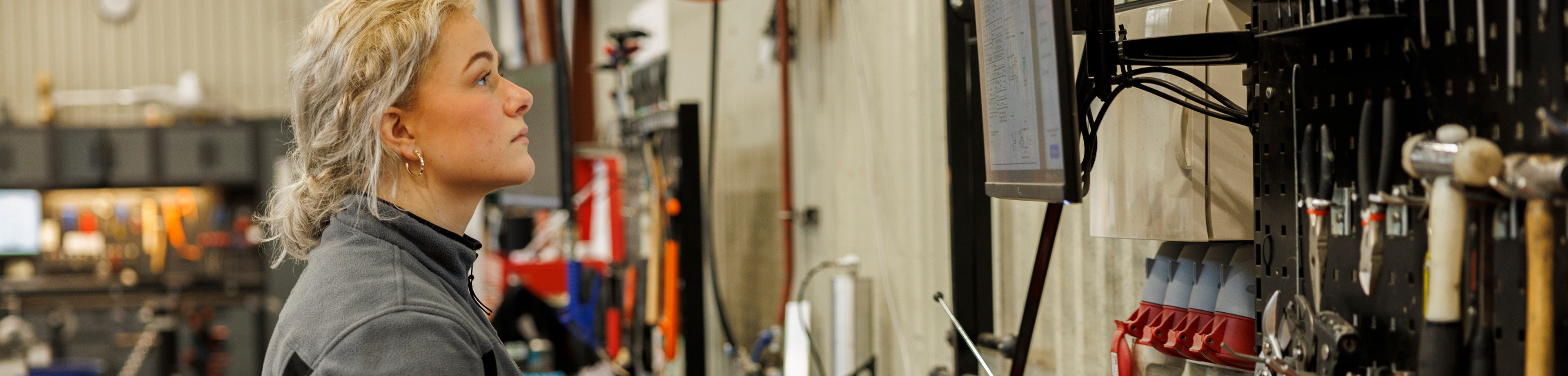 Vrouw werkt op pc in werkplaats