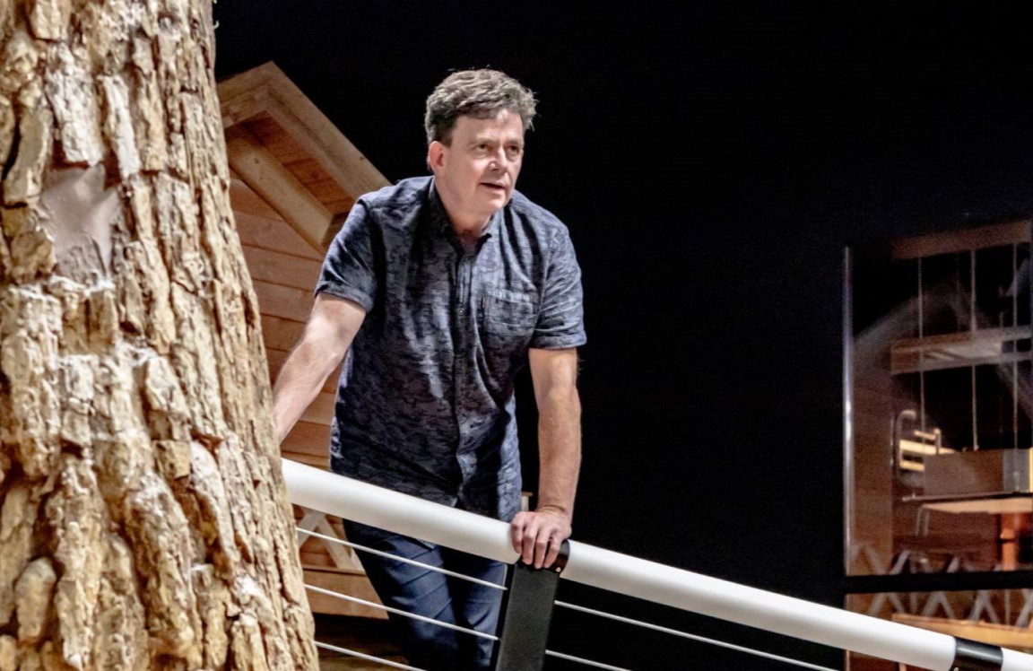 Een ondernemer die op een balkon staat en naar voren kijkt