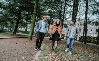 2 mannen en een vrouw lopen door een park