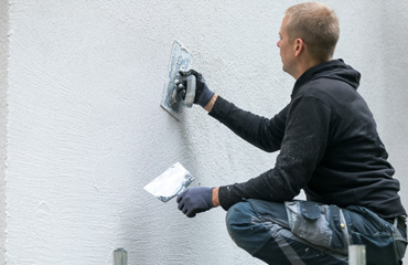 Stucadoor die aan het werk is