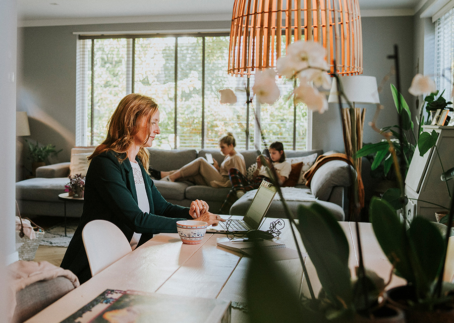 Vrouw zit thuis achter haar laptop
