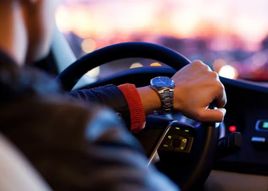 1 arm die het stuur van een auto vasthoudt.