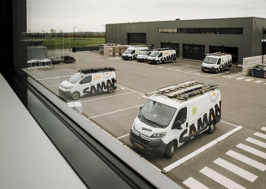 Zicht op een parkeerplaats van een bedrijventerrein met busjes