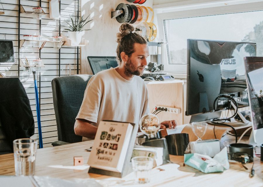 Een man aan het werk achter een groot computerscherm