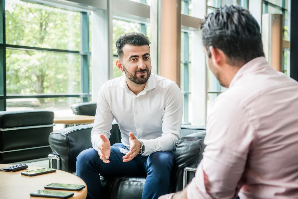 2 mannen in overhemden hebben een gesprek