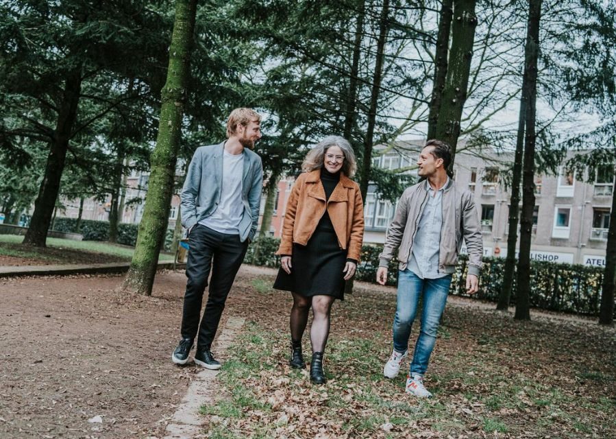 3 mensen wandelen in een park en praten met elkaar.