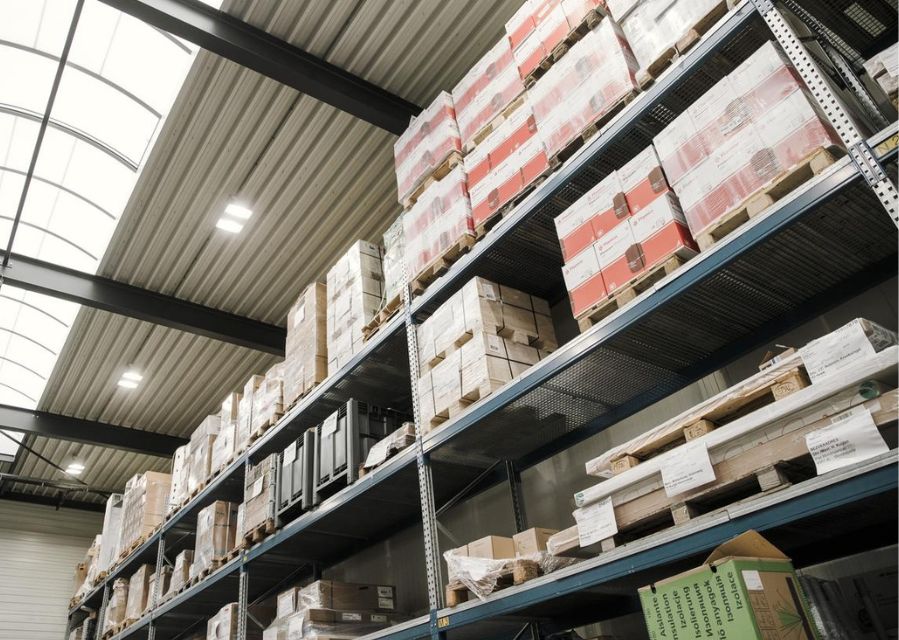 Stellingen gevuld met voorraad op pallets in een magazijn.