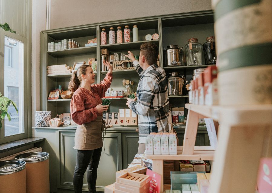 Twee mensen staan in een winkel voor een stellage met verkoop-producten.