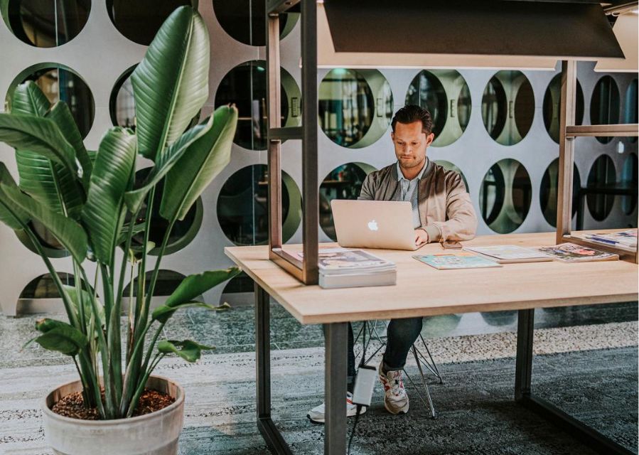 Een man achter zijn laptop aan een tafel.