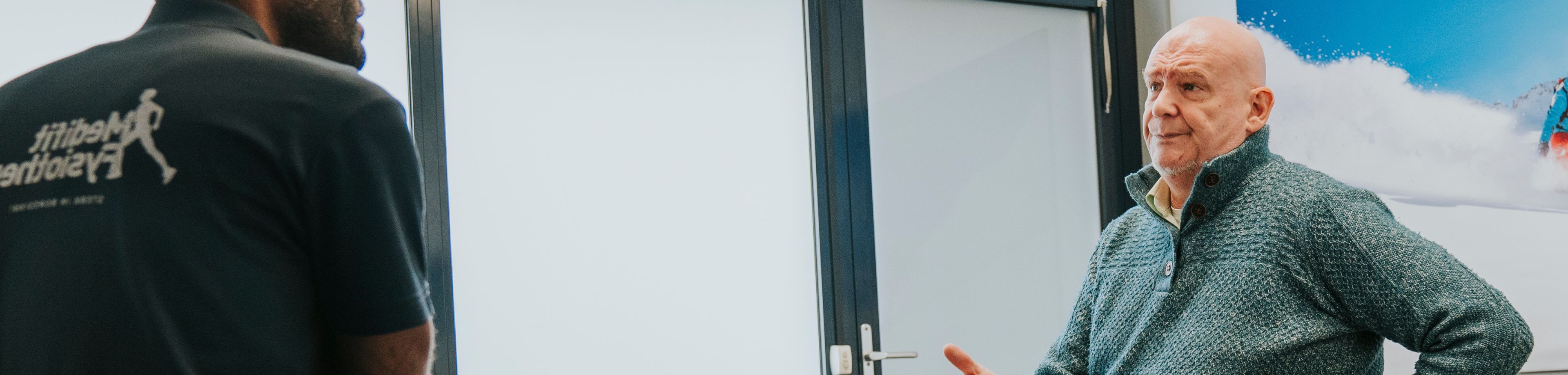 Vier mensen lopen door een park. Een vrouw ondersteunt een man, die door een blessure moeite heeft met lopen.