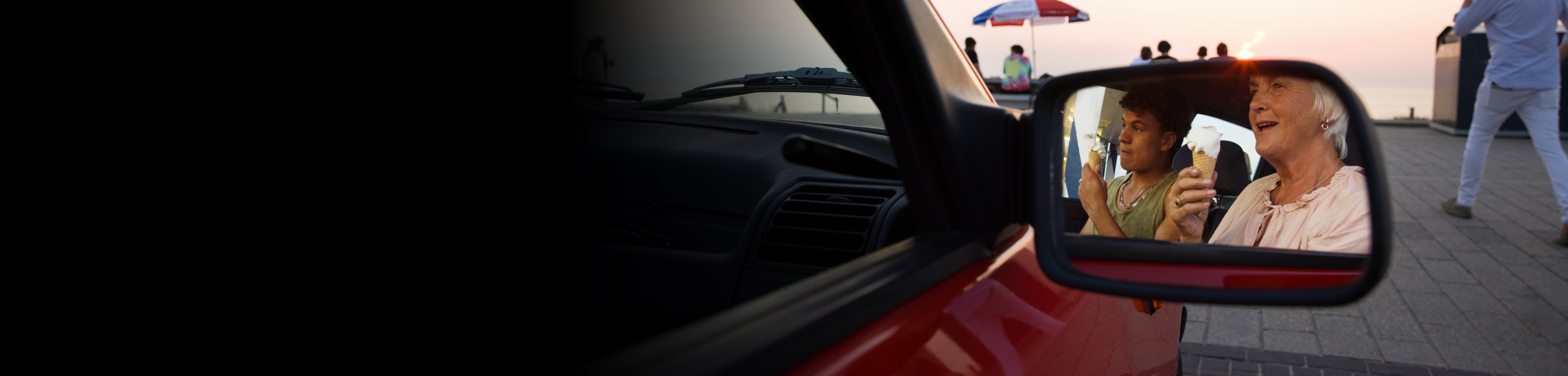 Vrouw en haar kleinzoon in een stilstaande auto, gezien via de zijspiegel