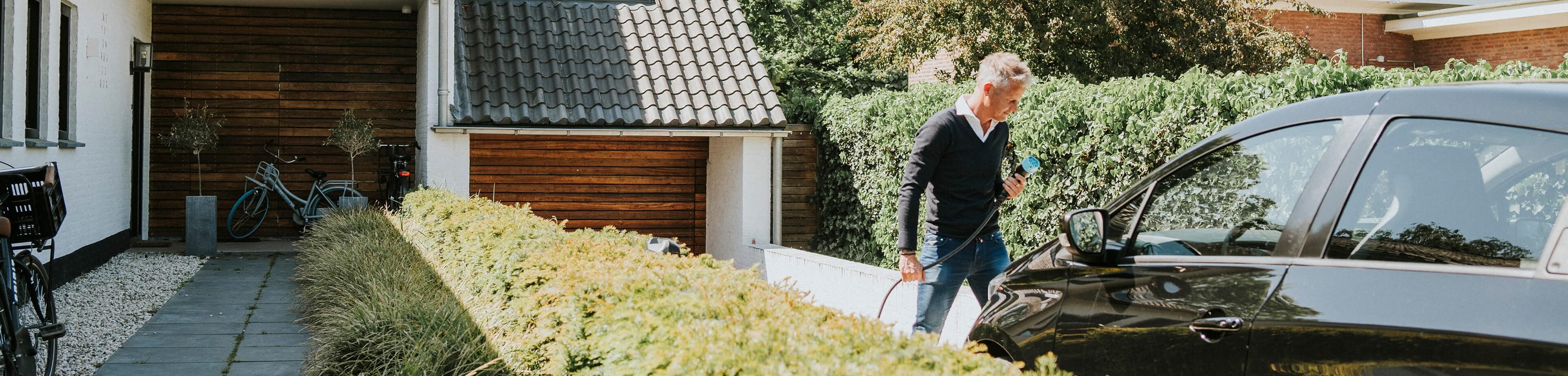 Man die zijn elektrische auto aan de oplader gaat doen
