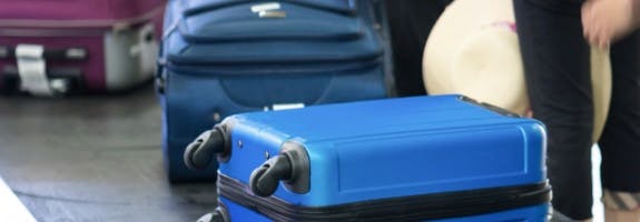 Verschillende koffers liggen op een bagageband op het vliegveld