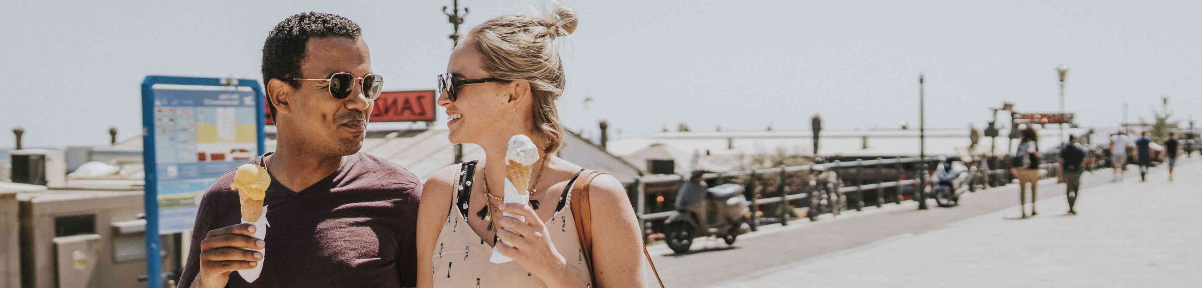 Man en een vrouw die op vakantie zijn en een ijsje eten. Zij sloten hun doorlopende reisverzekering bij Interpolis af met 15% korting.