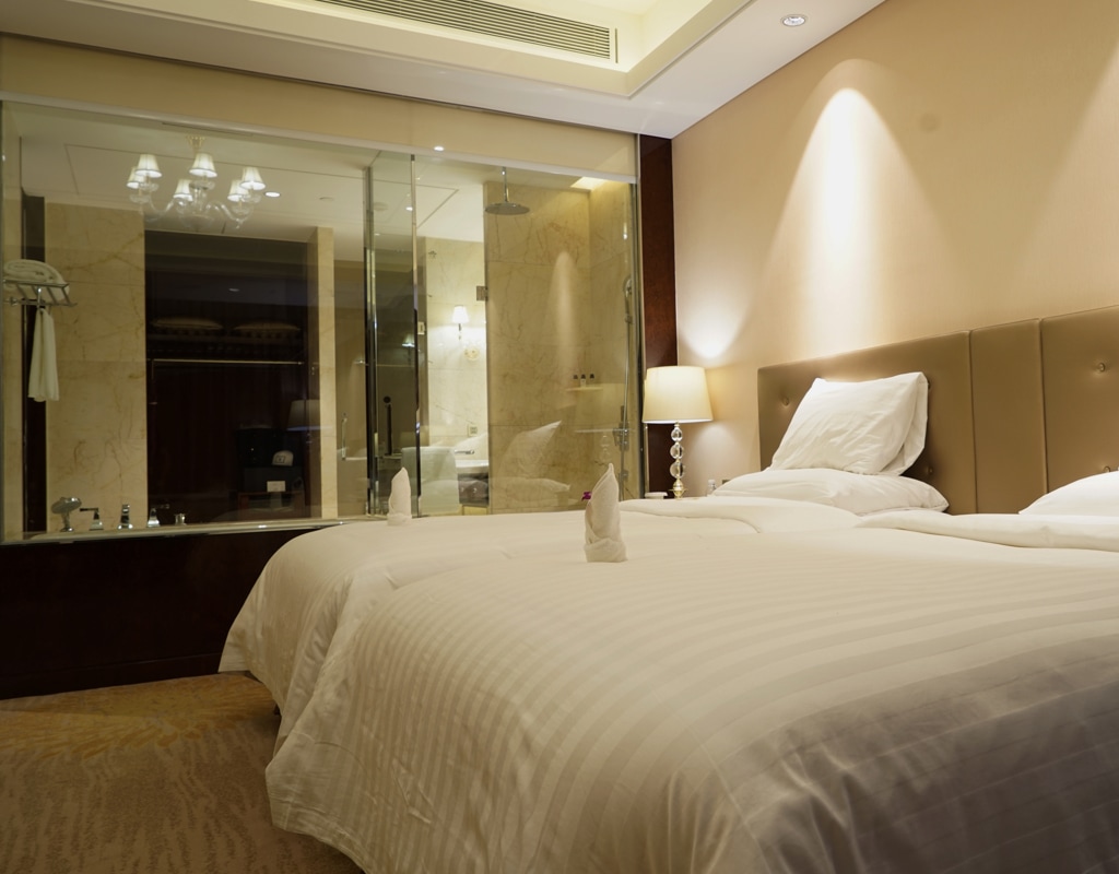 Opgemaakt bed in hotelkamer. Met de Kortlopende Annuleringsverzekering van Interpolis kunt u het onverwachts annuleren of het afbreken van een reis of vakantie verzekeren.