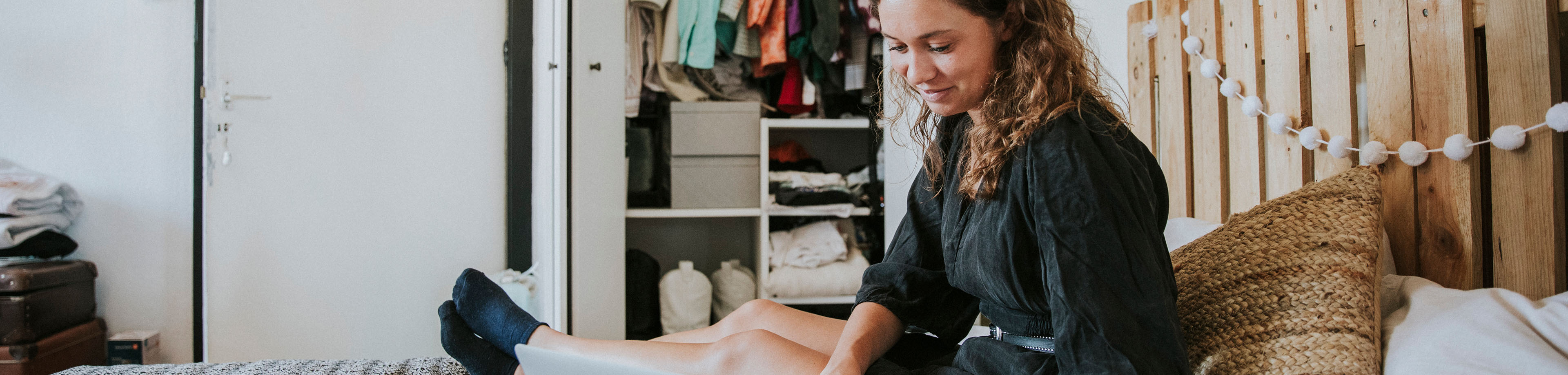 Student zit op bed en studeert op haar laptop | Interpolis studentenverzekeringen