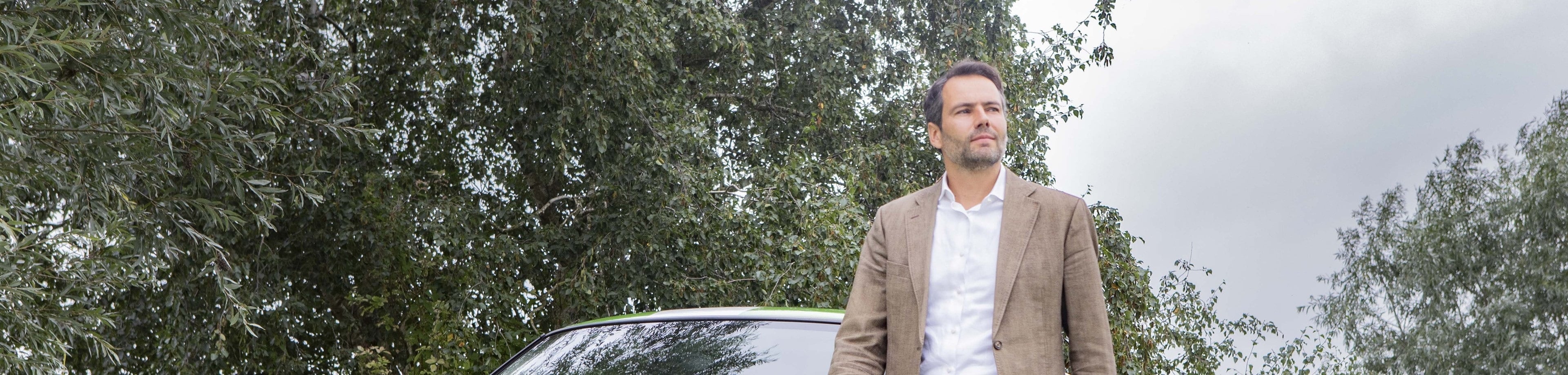 Zakenman met een auto op de achtergrond