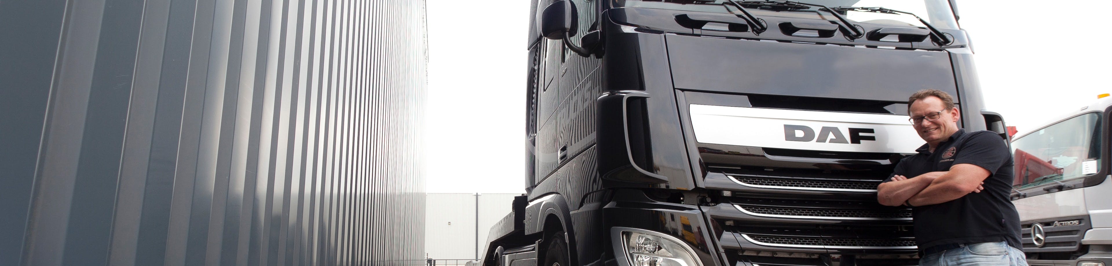 Een vrachtwagenchauffeur staat voor zijn vrachtwagen. Met de Vrachtautoverzekering bent u verzekerd voor schade die u met uw vrachtauto veroorzaakt.