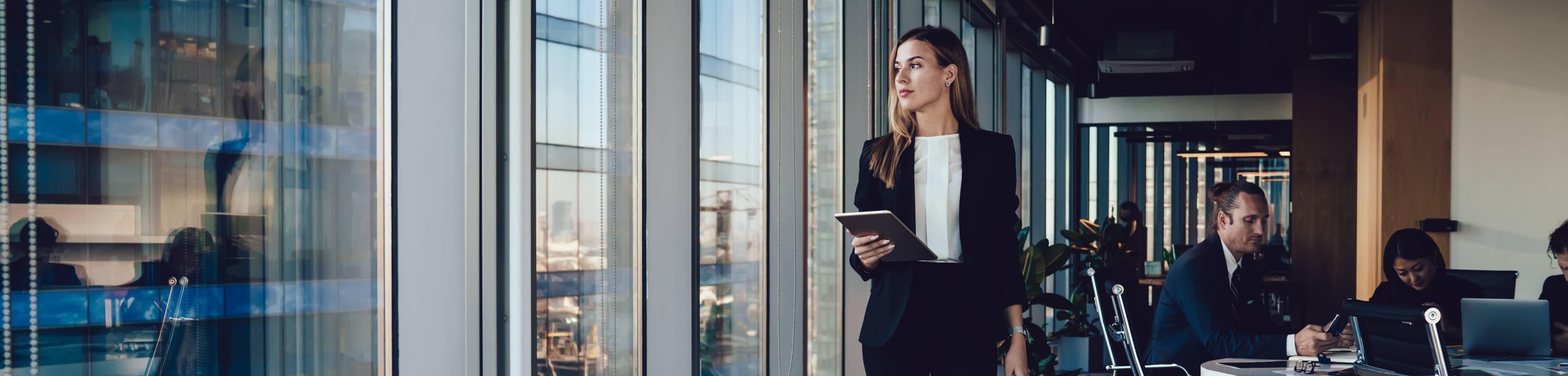 Ondernemer in een kantoorruimte die nadenkt over het verlengen van haar zakelijke verzekeringen