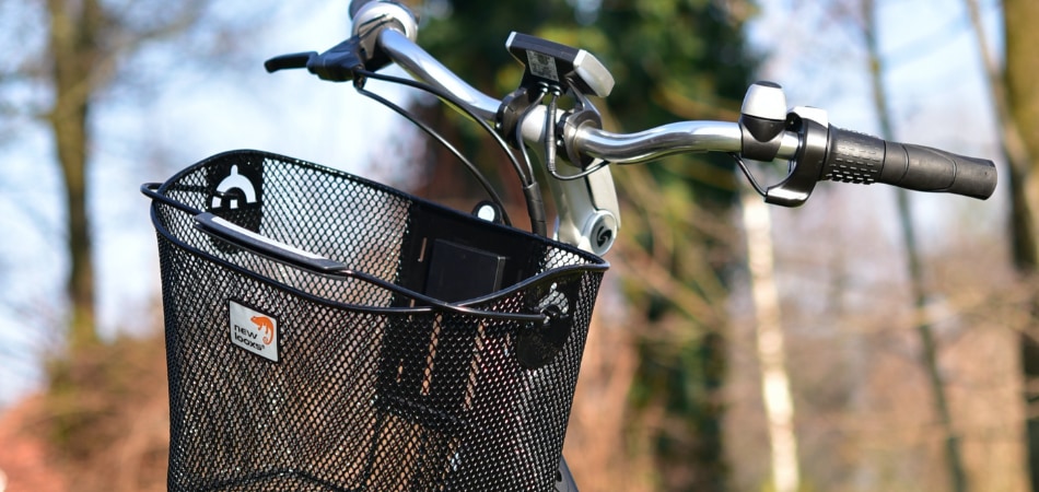 Het stuur van een e-bike met daaraan een fietsmand