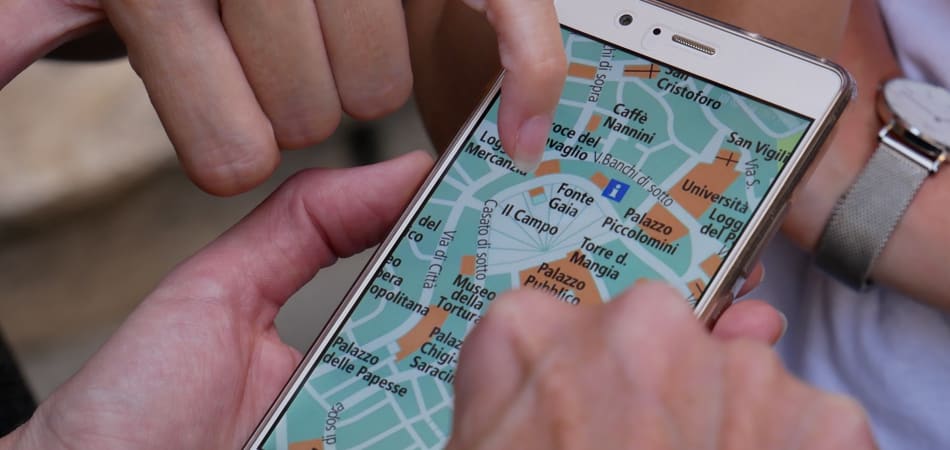 Twee mensen die op een smartphone bezig zijn met een routeplanner