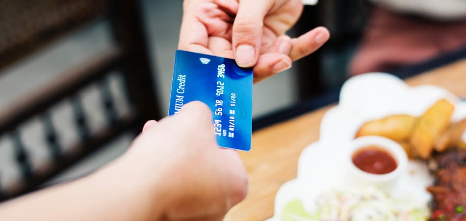 Een creditcard die van de ene persoon aan de andere gegeven wordt