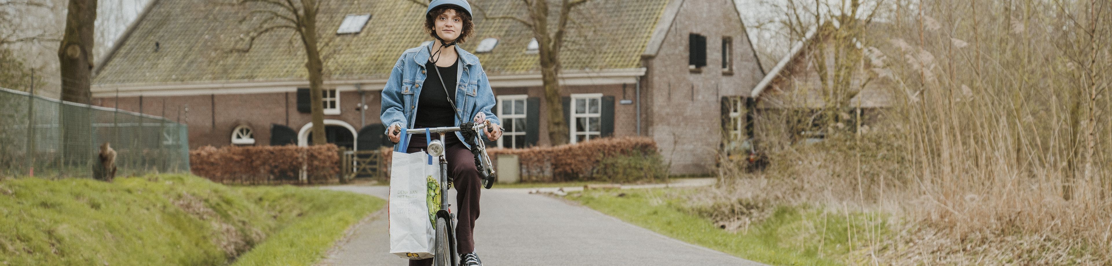 Een persoon fietst op een weg in het buitengebied.