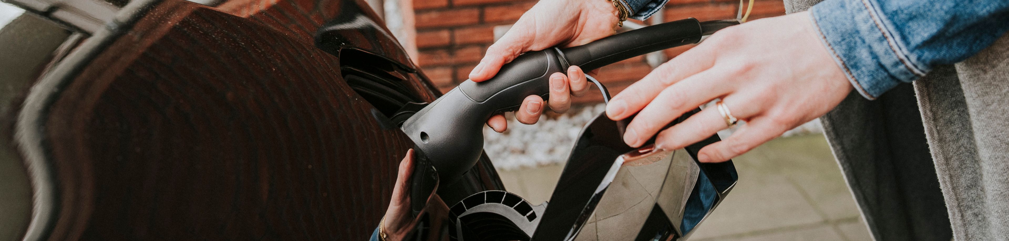 Het inpluggen van de oplaadstekker van een elektrische auto.