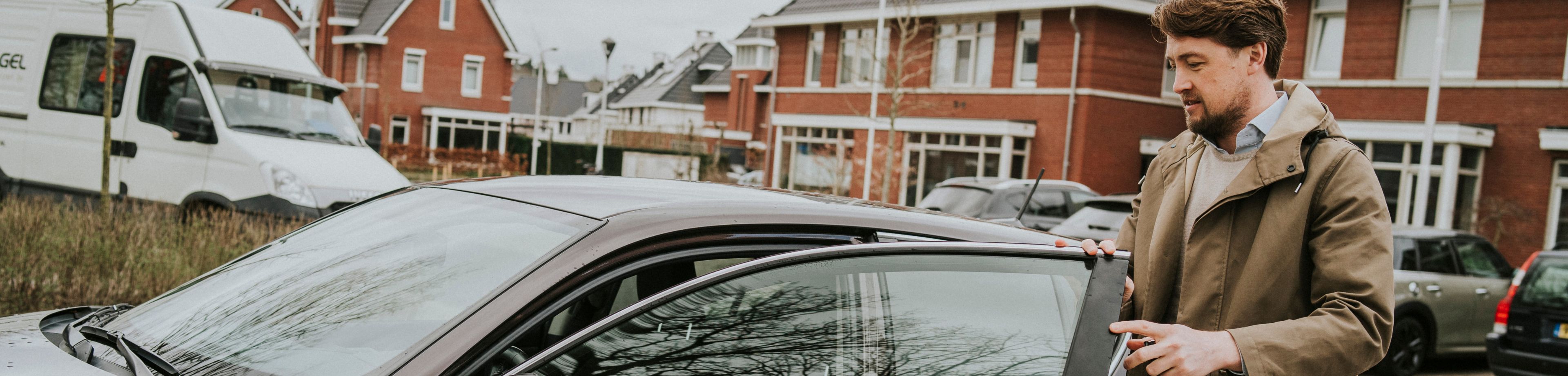 Een man heeft zijn autoportier open en staat op het punt om in te stappen