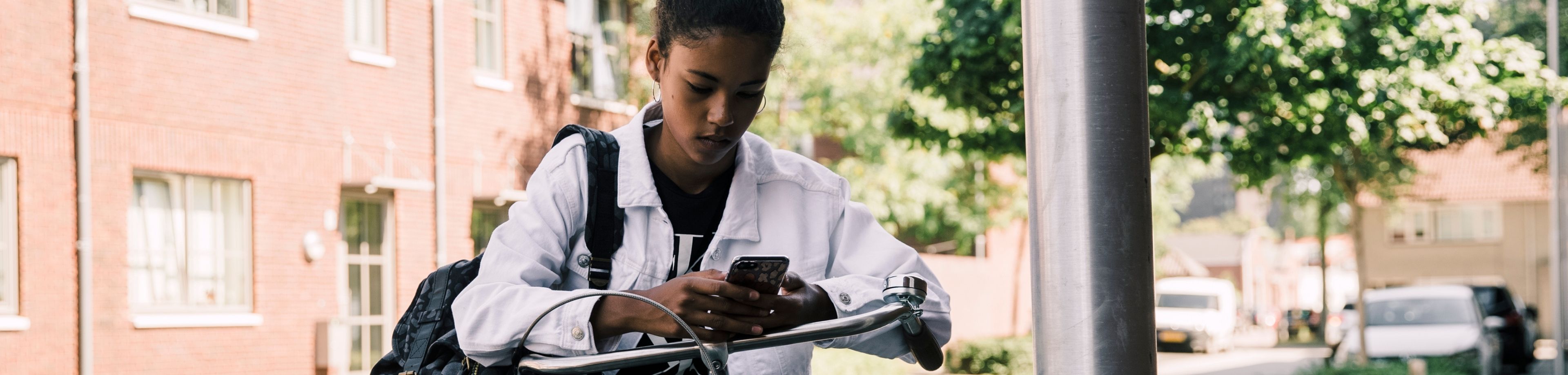 Jonge fietser kijkt op haar telefoon