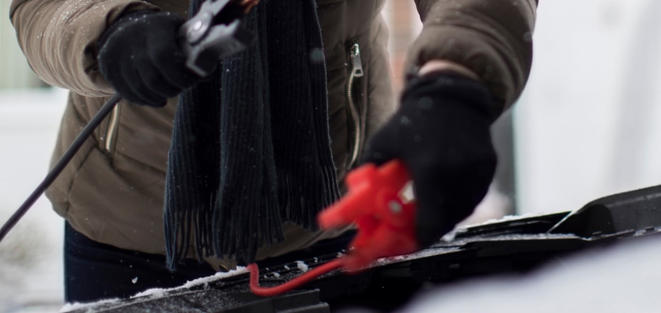 Iemand die vastgevroren ruitenwissers op een auto losmaakt