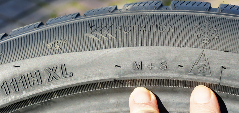 Deze afbeelding toont de zijkant van een autoband met duidelijke markeringen zoals 'M+S' en het 3PMSF-symbool (een sneeuwvlok in een berg).