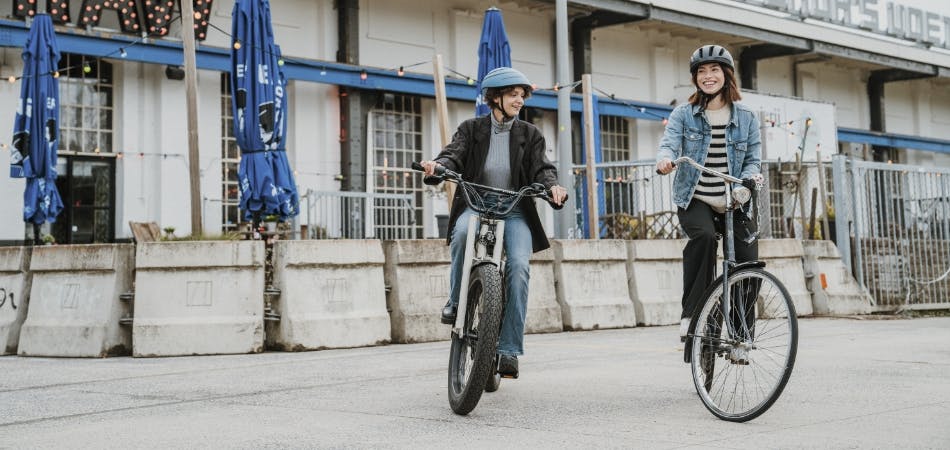 2 vrouwen fietsen met fietshelm op