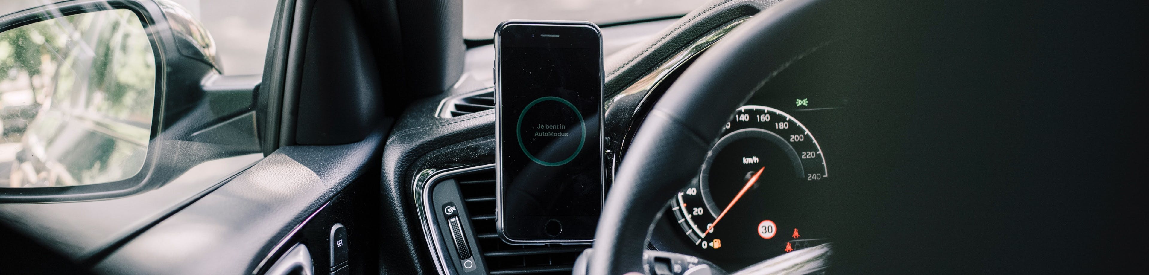 telefoon met de AutoModus app in een smartphonehouder in een auto