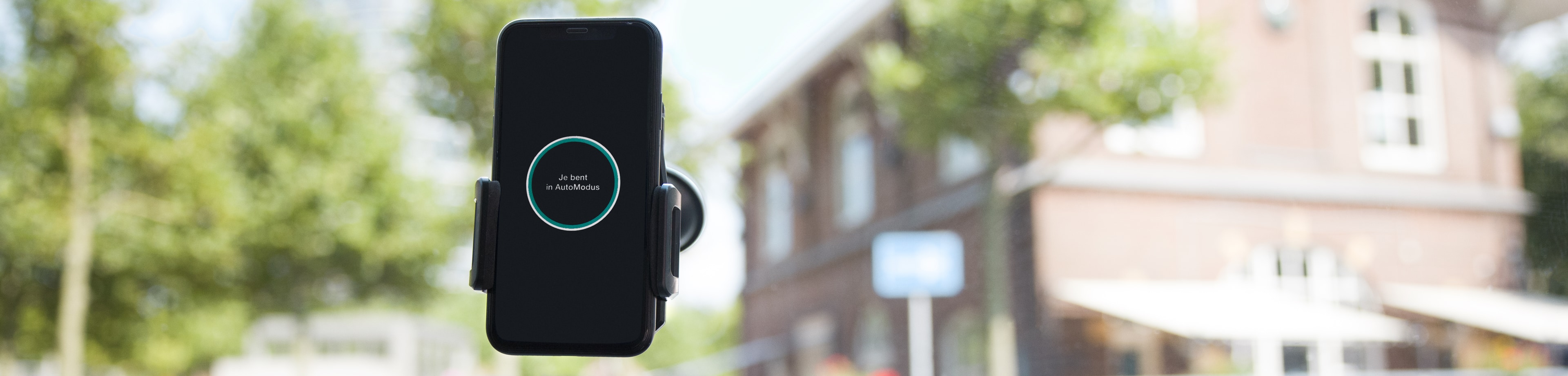 De AutoModus app van Interpolis in een telefoonhouder in een auto