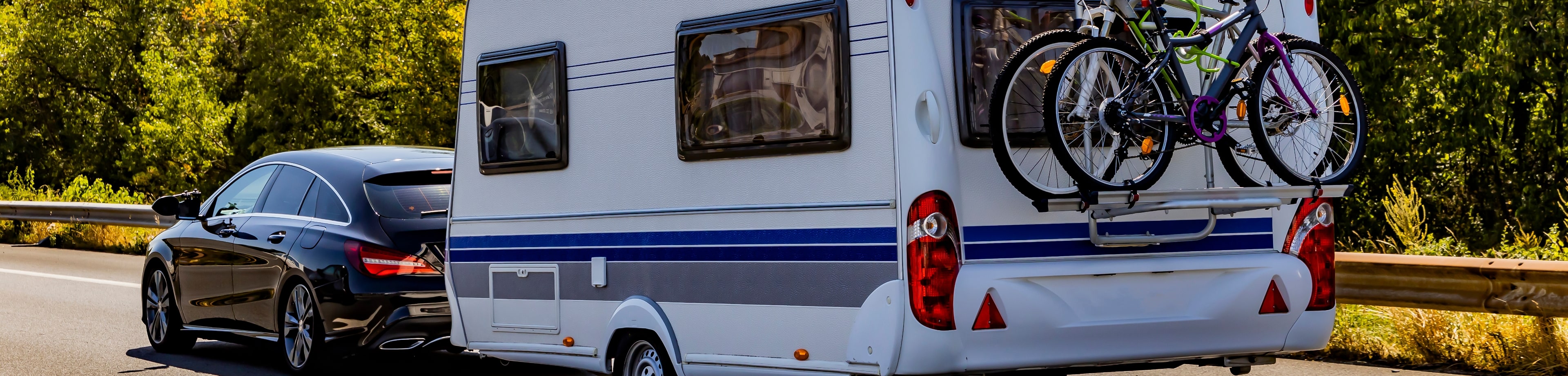 Auto met caravan achter rijdt op de snelweg.