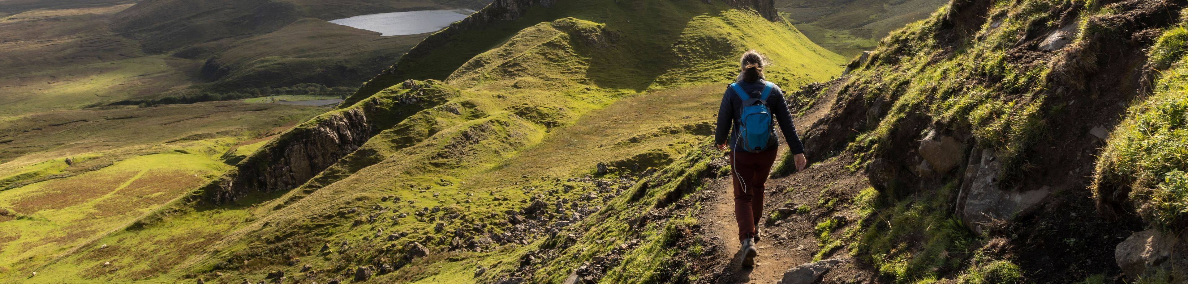 Wandelaar op een pad langs een berghelling in Schotland
